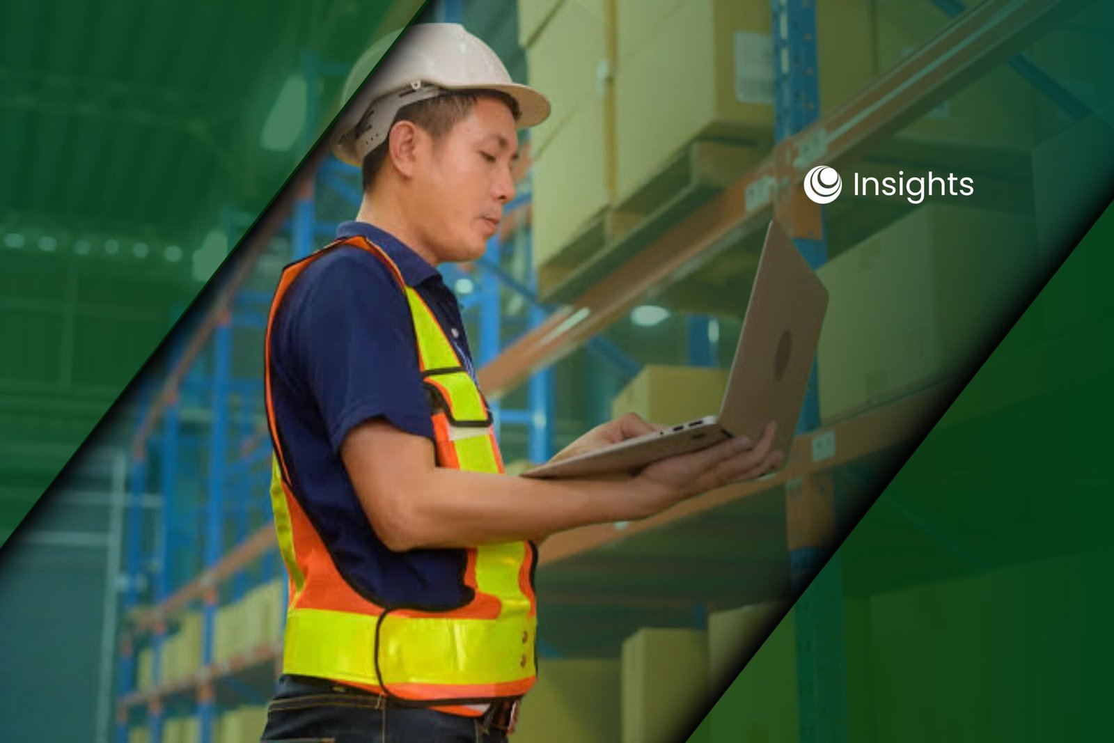 A warehouse worker wearing a hard hat and safety vest while using a laptop in front of storage shelves.